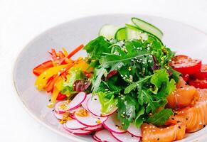 gerookt of gezouten Zalm salade met komkommers, rucola, paprika's en radijs foto