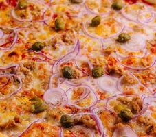 heerlijk pizza tonijn met tomaten, olijven, ui en kappertjes foto