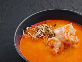 traditioneel Thais soep Tom yam in zwart kom foto