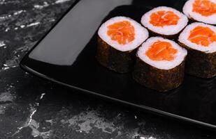 Zalm maki sushi Aan zwart steen bord foto