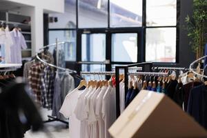 interieur van modern mode op te slaan met elegant kleren Aan rekken, modieus merk ontwerp en formeel slijtage in boetiek. leeg kleding toonzaal in boodschappen doen winkelcentrum met elegant handelswaar. foto