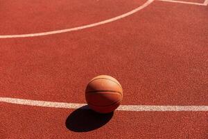 basketbal Aan rechtbank verdieping dichtbij omhoog met wazig arena in achtergrond. foto