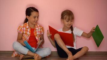 lief weinig meisjes zijn lezing een boek. de concept van onderwijs. geïsoleerd Aan roze achtergrond foto