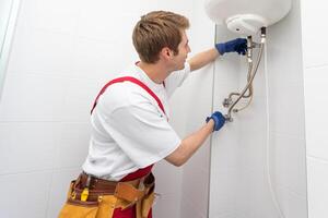 professioneel loodgieter controle een boiler en pijpen, boiler onderhoud concept. foto