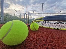 geel tennis ballen en racket Aan moeilijk tennis rechtbank oppervlak, top visie tennis tafereel foto