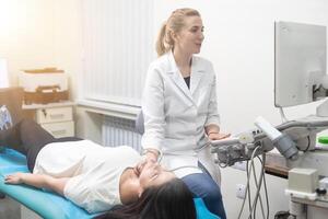vrouw endocrinoloog maken echografie naar een vrouw geduldig in een echografie kantoor. echografie diagnostiek foto