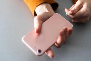 vrouw handen aansluiten een oplader in een slim telefoon foto