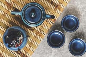 serviesgoed voor thee ceremonie top visie. blauw thee reeks pottenbakkerij Aan bamboe servet. foto