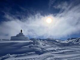 alleen persoon staat Aan top van een sneeuw gedekt berg foto