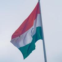 indiase vlag hoog op connaught plaats met trots in blauwe lucht, indiase vlag wapperen, indiase vlag op onafhankelijkheidsdag en republiek dag van india, tilt-up shot, wuivende indische vlag, har ghar tiranga foto