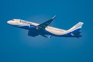 nieuw Delhi, Indië, december 25 2023 - indigo luchtbus a320 nemen uit van indra Gandhi Internationale luchthaven Delhi, indigo huiselijk vliegtuig vliegend in de blauw lucht gedurende dag tijd foto