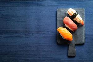 elegante sushi op houten tafel. wat nigiri, met sojasaus en eetstokje foto