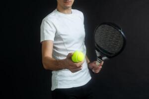 padel tennis speler met racket in hand. peddelen tennis, Aan een zwart achtergrond. foto