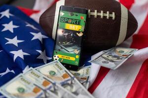online sport- wedden. dollars zijn vallend Aan de achtergrond van een hand- met een smartphone en een voetbal bal. creatief achtergrond, het gokken foto