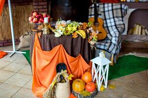 herfst landelijk fotozone. mooi herfst samenstelling met pompoenen en bladeren in de buurt houten muur. gitaar, oranje kleding en pompoenen. foto