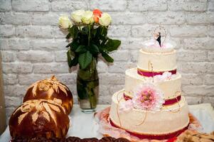 wit bruiloft taart met bloemen en speciaal ceremonie brood of brood. bruiloft concept. detailopname. foto