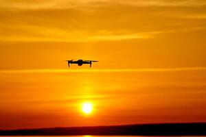 dar quadcopter met digitaal camera vliegend Bij zonsondergang foto