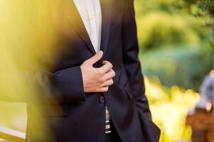 zakenman draagt een jas, mannelijk handen close-up, bruidegom krijgen klaar in de ochtend- voordat bruiloft ceremonie foto