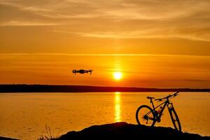 mooi zonsondergang door de rivier- en de silhouet van een fiets foto