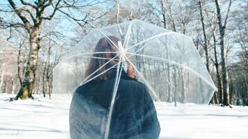 meisje in beweging een transparant paraplu omringd door sneeuw foto