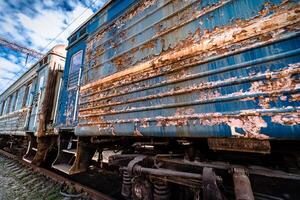 oud roestig verweerd geschild verf van een oud wagen. blauw verlaten spoorweg koets. oud treinstation. foto