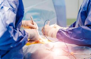 medisch team het uitvoeren van chirurgie in in werking kamer, dichtbij omhoog foto