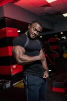 sterk bodybuilder met krachtig spieren poseren voor camera. gezond knap Mens werken in de Sportschool. foto