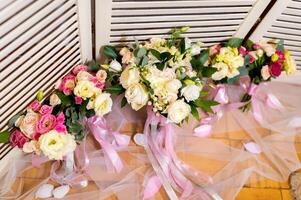 decoratie van rozen en decoratief planten. bloemen concept met helder bloemen van bruid tegen hout decoratie foto