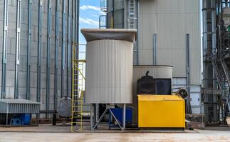 staal fabriek containers Aan blauw lucht. agrarisch tank van brandstof. buitenkant van lift. foto