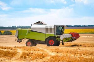 combineren werken Aan de groot tarwe veld- oogsten geel rijp tarwe. agrarisch concept foto