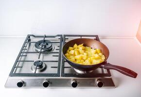 Koken gebakken aardappelen. frituren aardappelen Aan de frituren pan foto