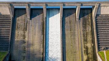 antenne visie van een dam met water trapsgewijs naar beneden haar overlaat, presentatie van industrieel architectuur en hernieuwbaar energie concept. foto