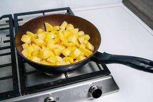 aardappelen wezen gebakken in een pan. eigengemaakt diep gebakken chips. foto