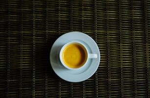 heet koffie in een wit kop Aan een bruin achtergrond. ochtend- koffie Bij huis foto