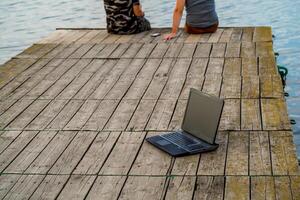 laptop Aan de pier. Mens werken Aan pier foto