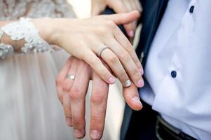 paar handen met bruiloft ringen. getrouwd vrouw vingers met echtgenoot. foto