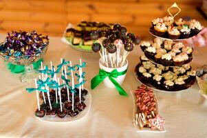 elegant en elegant snoep bar met taarten, muffins, snoepjes, koekjes snoepgoed, lolly. bruiloft banket decoratie. foto