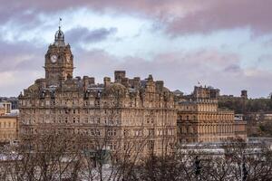 historisch gebouw met klok toren tegen een bewolkt lucht Bij schemering, Edinburgh, Schotland. foto