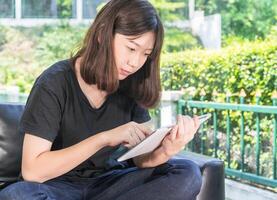 jong meisje aan het studeren online van digitaal tablet in salon foto