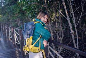 Aziatisch vrouw staand Aan de houten trottoir ontspannende reizen natuur in de mangrove Woud resting Aan vakantie vakantie samen, levensstijl reizen concepten. foto