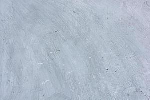 grijze betonnen muur met krassen en scheuren. foto