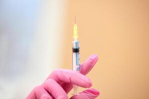 detailopname van injectiespuit in dokter hand. medisch apparatuur. injectie of vaccin. foto