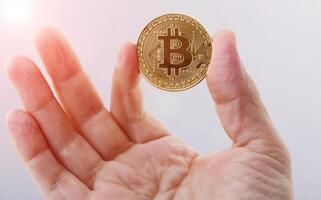 gouden bitcoin Holding in man's hand- Aan wit achtergrond foto