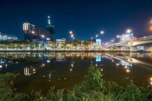 ho chi minh stad horizon en de Saigon rivier. verbazingwekkend kleurrijk nacht visie van wolkenkrabber en andere modern gebouwen Bij downtown foto