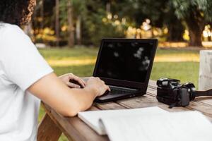 een persoon met een laptop in een park. foto