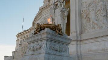 de vlam van heerlijkheid brandend onder een standbeeld in Rome foto