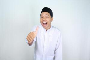 vrolijk moslim Aziatisch Mens geschreeuw terwijl geven duim omhoog geïsoleerd Aan wit achtergrond foto