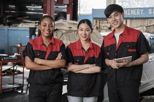 portret van multiraciaal professioneel monteur team armen gekruiste en kijken Bij camera, werk Bij auto onderhoud garage, gelukkig onderhoud banen, controleren en reparatie bezetting in automotive industrie bedrijf. foto