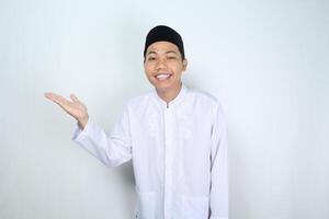 aantrekkelijk moslim Aziatisch Mens presenteren hand- naar de Rechtsaf kant met glimlachen gezicht geïsoleerd Aan wit achtergrond, op zoek Bij camera foto