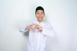 zelfverzekerd Aziatisch moslim Mens geven hart vorm met glimlach Bij camera foto